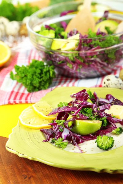 Fresh vegetable salad in bowl and plate on napkin on wooden table close-up — Stock Photo, Image