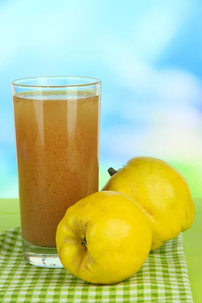 Sweet quince with juice on table on light blue background — Stock Photo, Image