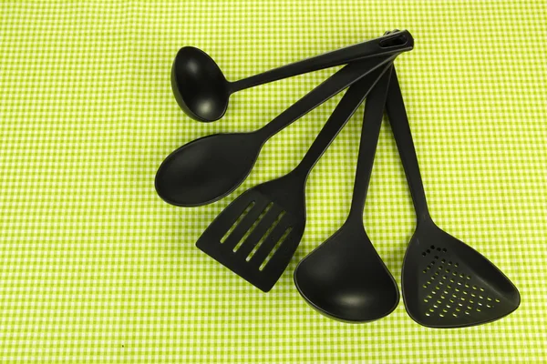 Plastic kitchen utensils on fabric background — Stock Photo, Image