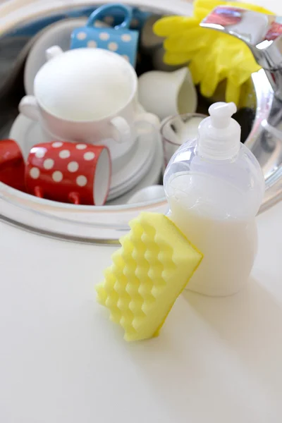 Stack of dishes soaking in kitchen sink — Stock Photo, Image