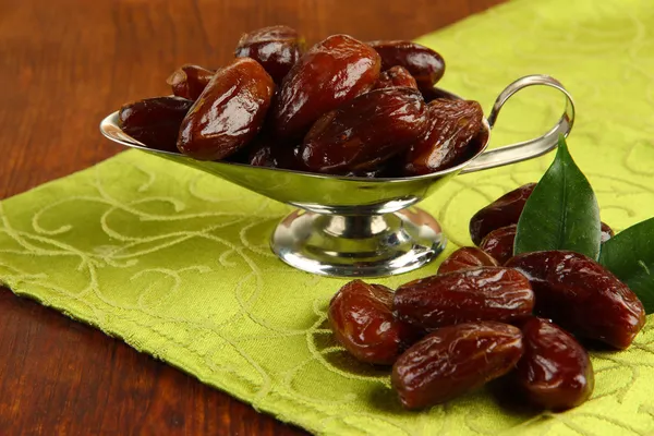 Dried dates in metal dish on fabric background — Stock Photo, Image