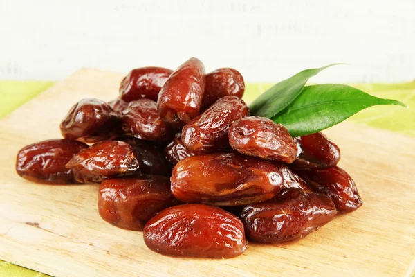 Dried dates on wooden stand on table on wooden background — Stock Photo, Image