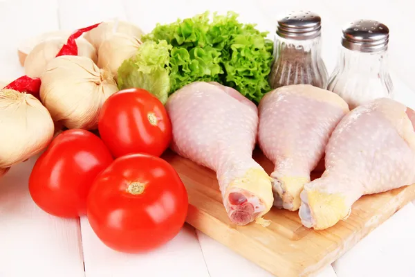 Raw chicken legs on wooden board close up — Stock Photo, Image