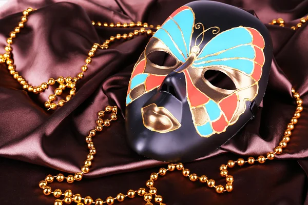 Kahverengi kumaş arkaplanındaki maske — Stok fotoğraf