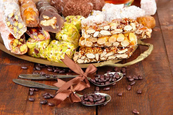 Вкусные восточные сладости на подносе, на сером деревянном фоне — стоковое фото