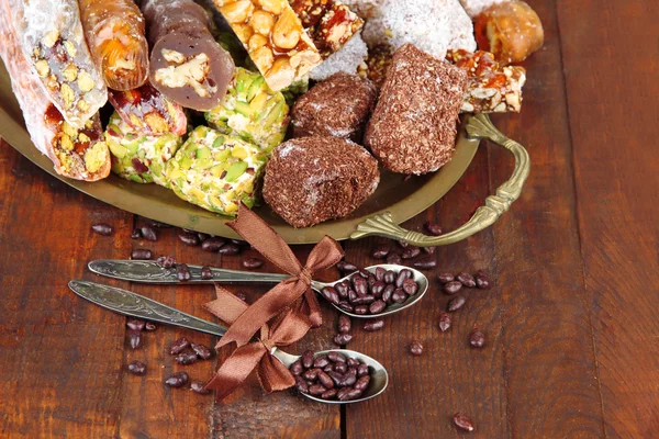 Ízletes keleti édességek a tálca szürke fából készült háttér — Stock Fotó