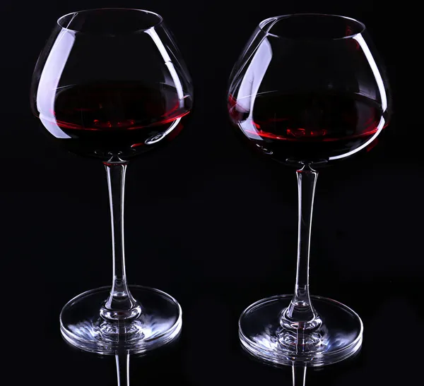 Rotweingläser, isoliert auf schwarz — Stockfoto