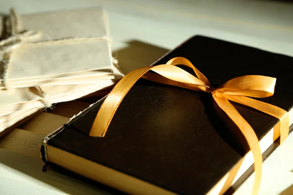 Book wrapped with color ribbon, on wooden background — Stock Photo, Image