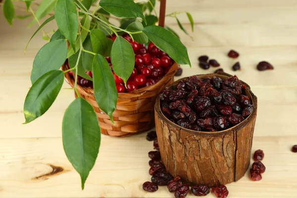 Fresh and dry cranberry in baskets on wooden table — Stock Photo, Image