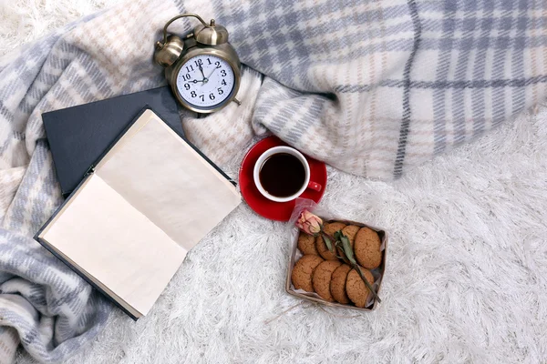 Sammansättning med varma Pläd, bok, kopp varm dryck på mattan färgbakgrund — Stockfoto
