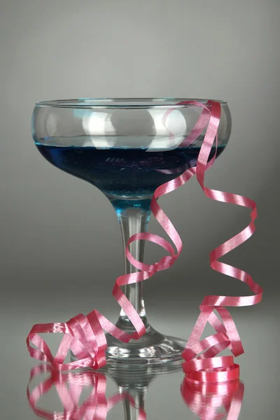 Glas cocktail en streamer afterparty op grijze achtergrond — Stockfoto