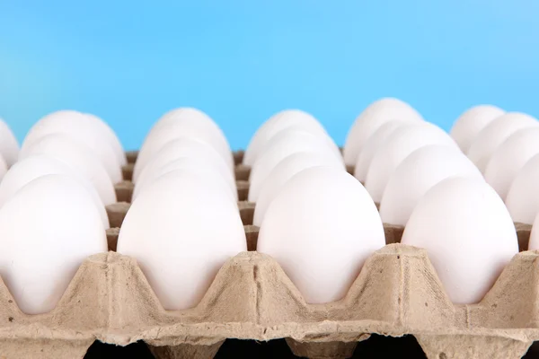 Eieren in de papierlade op hemelachtergrond — Stockfoto
