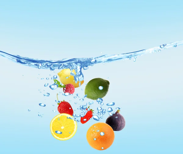 Fresh fruits dropped into water — Stock Photo, Image