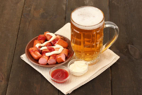 Bier und Grillwürste auf Holzboden — Stockfoto