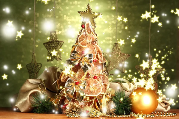 Bellissimo albero di Natale di limoni secchi con arredamento, su sfondo verde lucido — Foto Stock