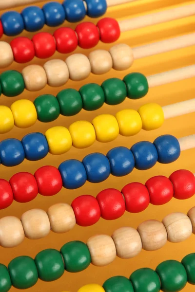 Bright wooden toy abacus, on yellow background — Stock Photo, Image