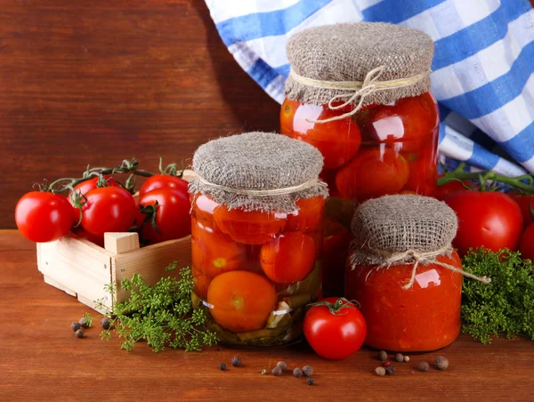 Läckra konserverad och färska tomater på träbord — Stockfoto