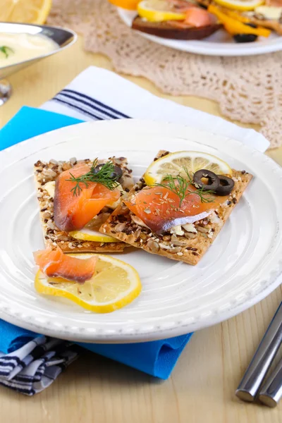 Sandwiches de salmón en plato sobre mesa de madera close-up —  Fotos de Stock