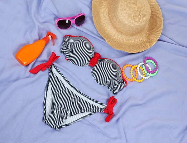 Traje de baño y artículos de playa sobre fondo morado —  Fotos de Stock