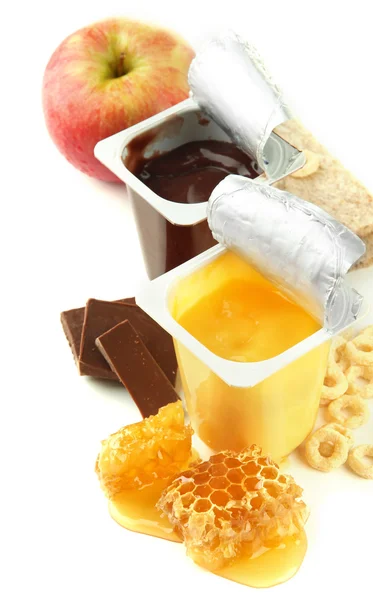 Tasty dessert in open plastic cup and honey combs, fruit, isolated on white — Stock Photo, Image