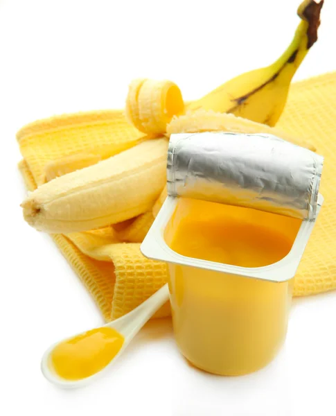 Välsmakande efterrätt i öppna plastmugg och banan, isolerad på vit — Stockfoto
