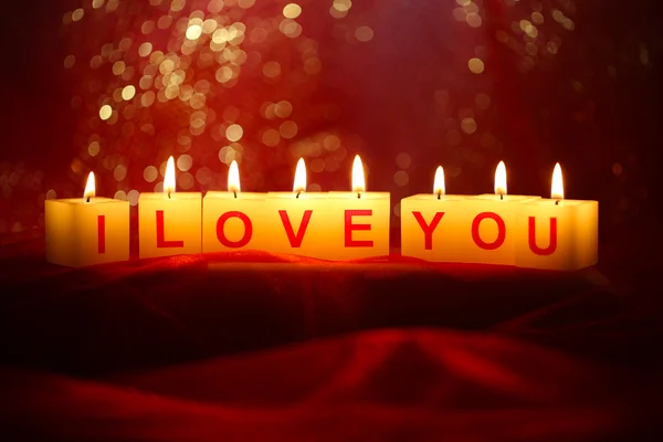 Candles with printed sign I LOVE YOU,on bright background — Stock Photo, Image