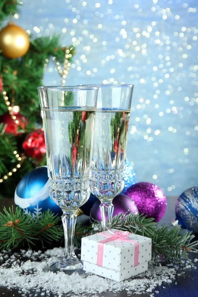 Composition with Christmas decorations and two champagne glasses, on bright background — Stock Photo, Image