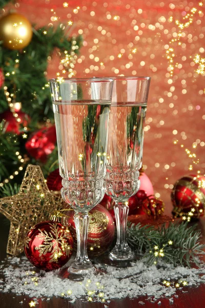 Composition with Christmas decorations and two champagne glasses, on bright background — Stock Photo, Image