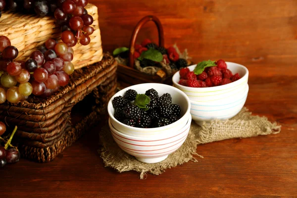 Assortment of juicy fruits and berries on wooden background Stock Image