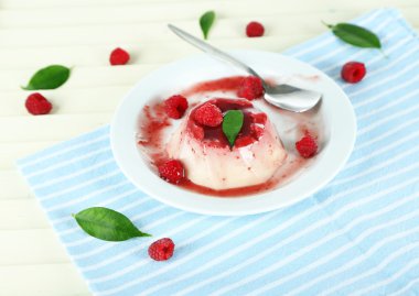 Panna cotta ahşap zemin üzerinde frambuaz sos ile