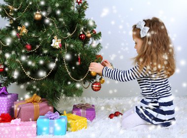 küçük kız odasında baubles ile Noel ağacı süsleme