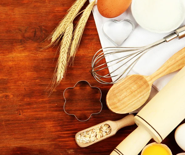 Concepto de cocina. Ingredientes básicos para hornear y utensilios de cocina en mesa de madera —  Fotos de Stock