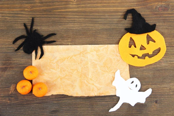 Old paper with Halloween decorations on grey wooden background — Stock Photo, Image