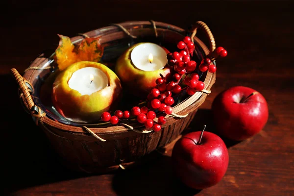 Composition with apples and candles in basket on wooden background — Stock Photo, Image