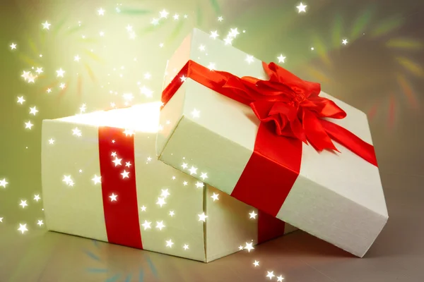 Gift box with bright light on it on bright background — Stock Photo, Image