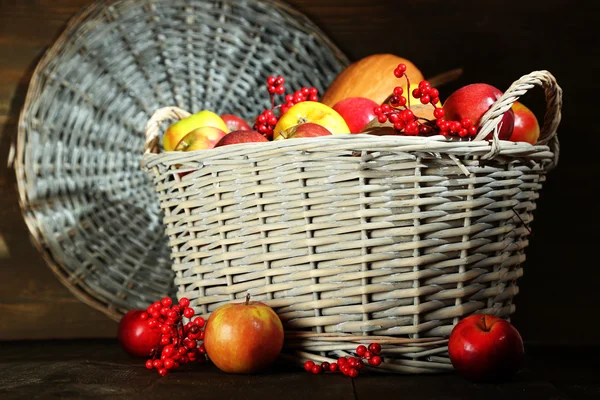 Сочные яблоки и тыква в деревянной корзине на столе крупным планом — стоковое фото