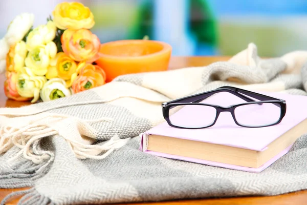 Sammansättning med gammal bok, glasögon, ljus, blommor och pläd på ljus bakgrund — Stockfoto