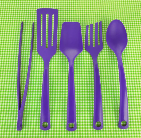 Plastic kitchen utensils on fabric background — Stock Photo, Image