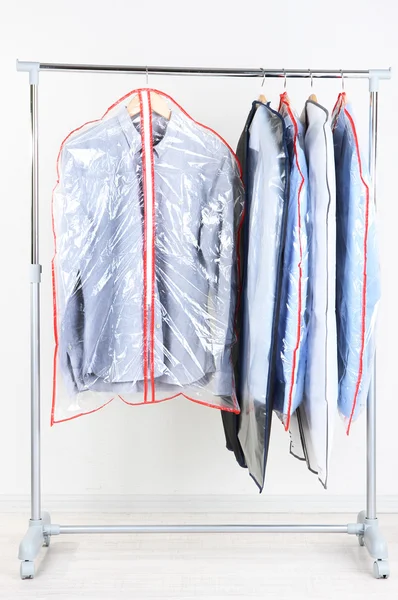 Office mannelijke kleding in gevallen voor het opslaan op hangers, op grijze achtergrond — Stockfoto