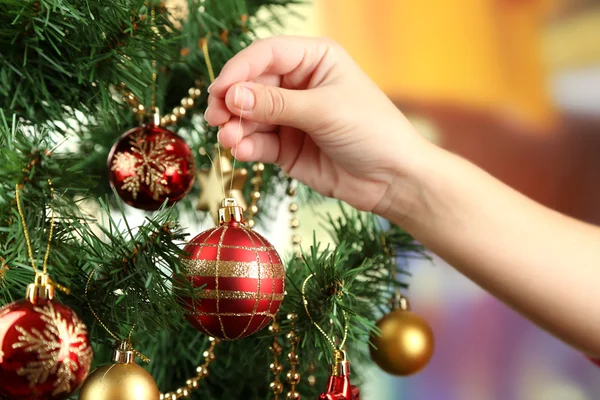 Decorating Christmas tree on bright background — Stock Photo, Image