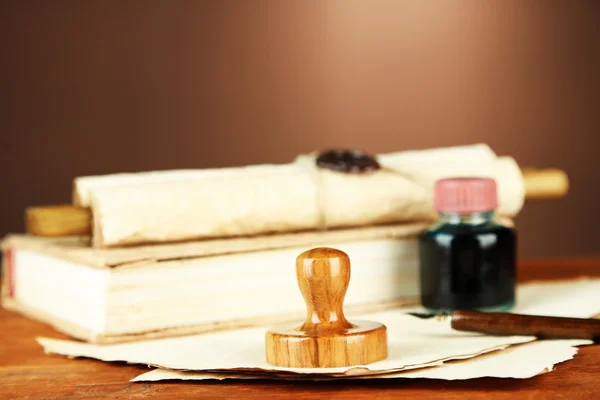 Wooden stamp, books and old papers on wooden table — Stock Photo, Image