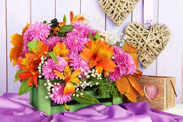 Flowers composition in crate with decorations on table on wooden background — Stock Photo, Image