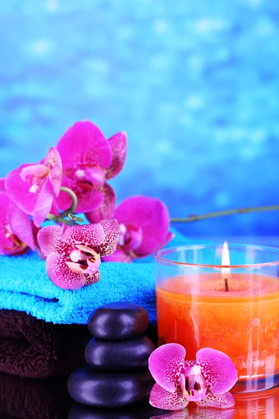Hermoso entorno de spa con orquídea sobre fondo azul — Foto de Stock