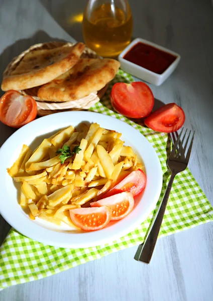 Rostige Bratkartoffeln auf Teller auf Holztisch in Großaufnahme — Stockfoto