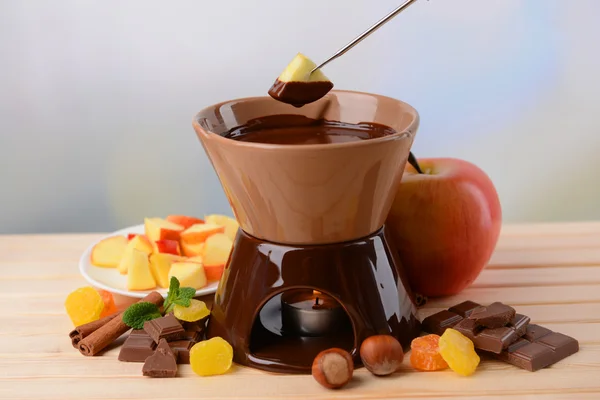 Çikolata fondü meyve üzerinde açık renkli ahşap tablo — Stok fotoğraf