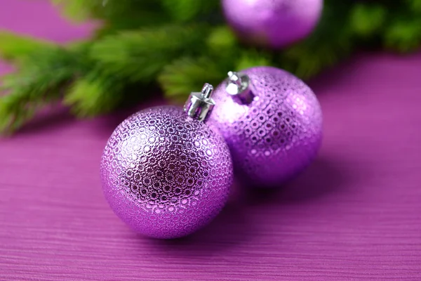 Christmas balls on fir tree, on color background — Stock Photo, Image