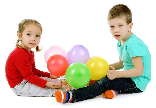 Küçük çocuklar üzerinde beyaz izole renkli balonları — Stok fotoğraf