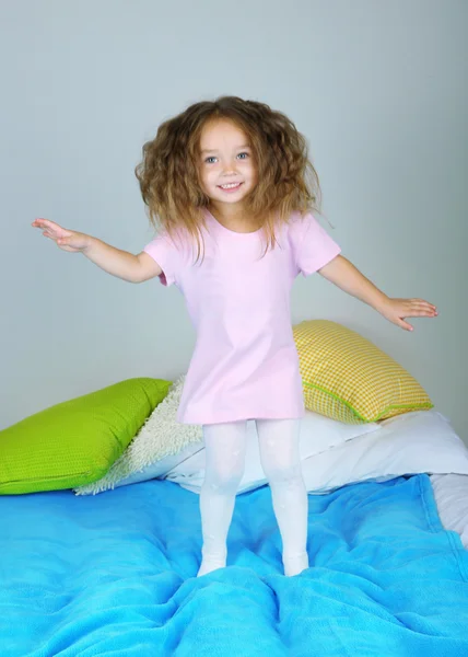 Lilla flickan hoppar på sängen — Stockfoto