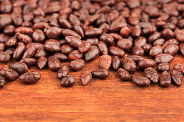 チョコレート茶色の木製の背景上にヒマワリの穀物 — ストック写真