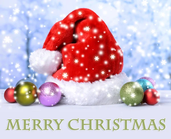 Composición con sombrero rojo de Santa Claus y decoraciones navideñas sobre fondo claro — Foto de Stock